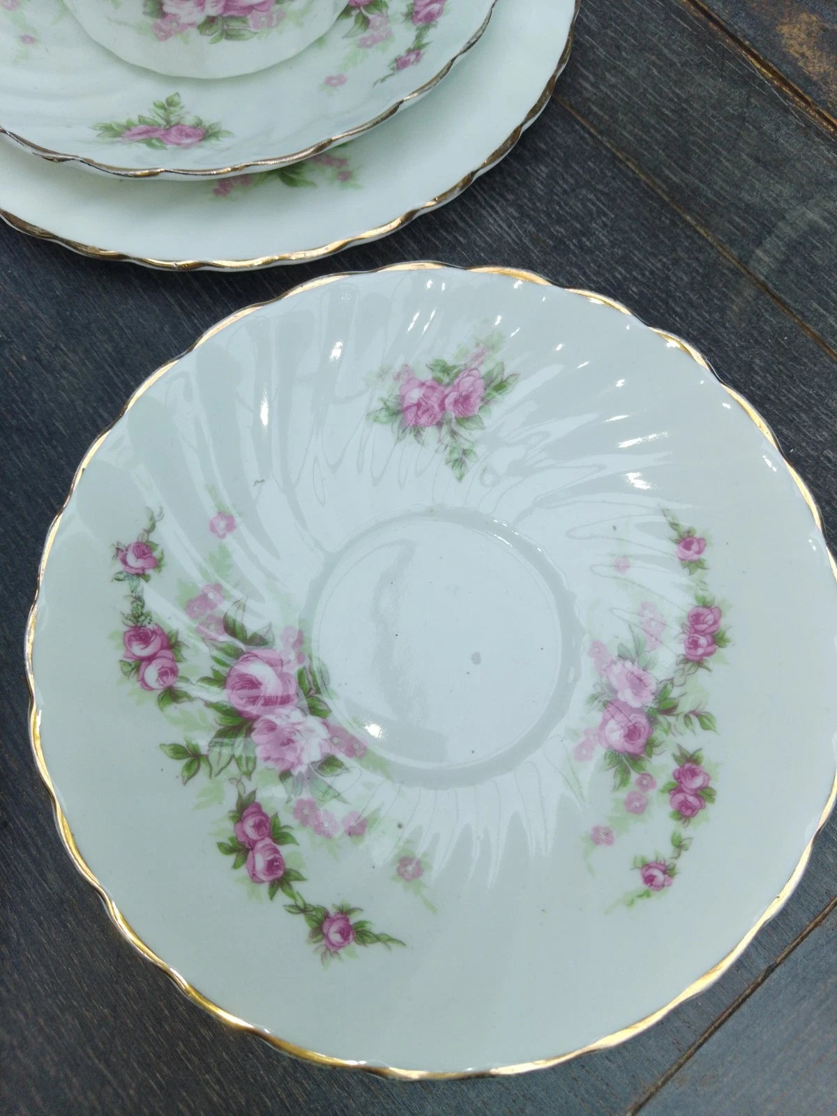 Antique pink rose tea set saucer with floral design and gold trim on white porcelain