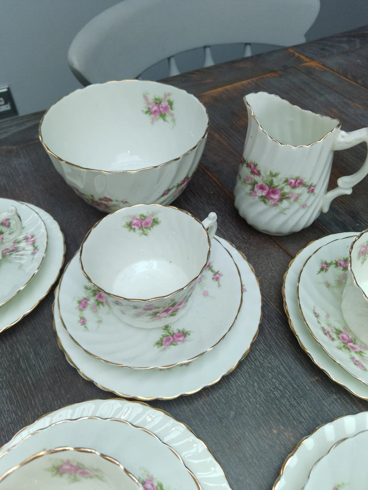 Antique pink rose tea set featuring delicate floral patterns on white porcelain with gold trim