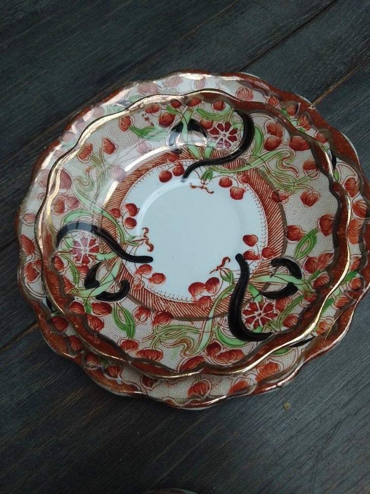 Antique Imari tea trio decorative plates with floral and fruit patterns on wooden surface