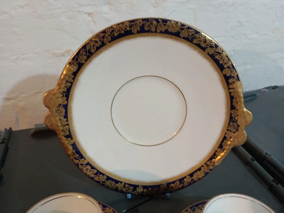 Adderleys cobalt blue tea set featuring a white saucer with ornate gold floral border