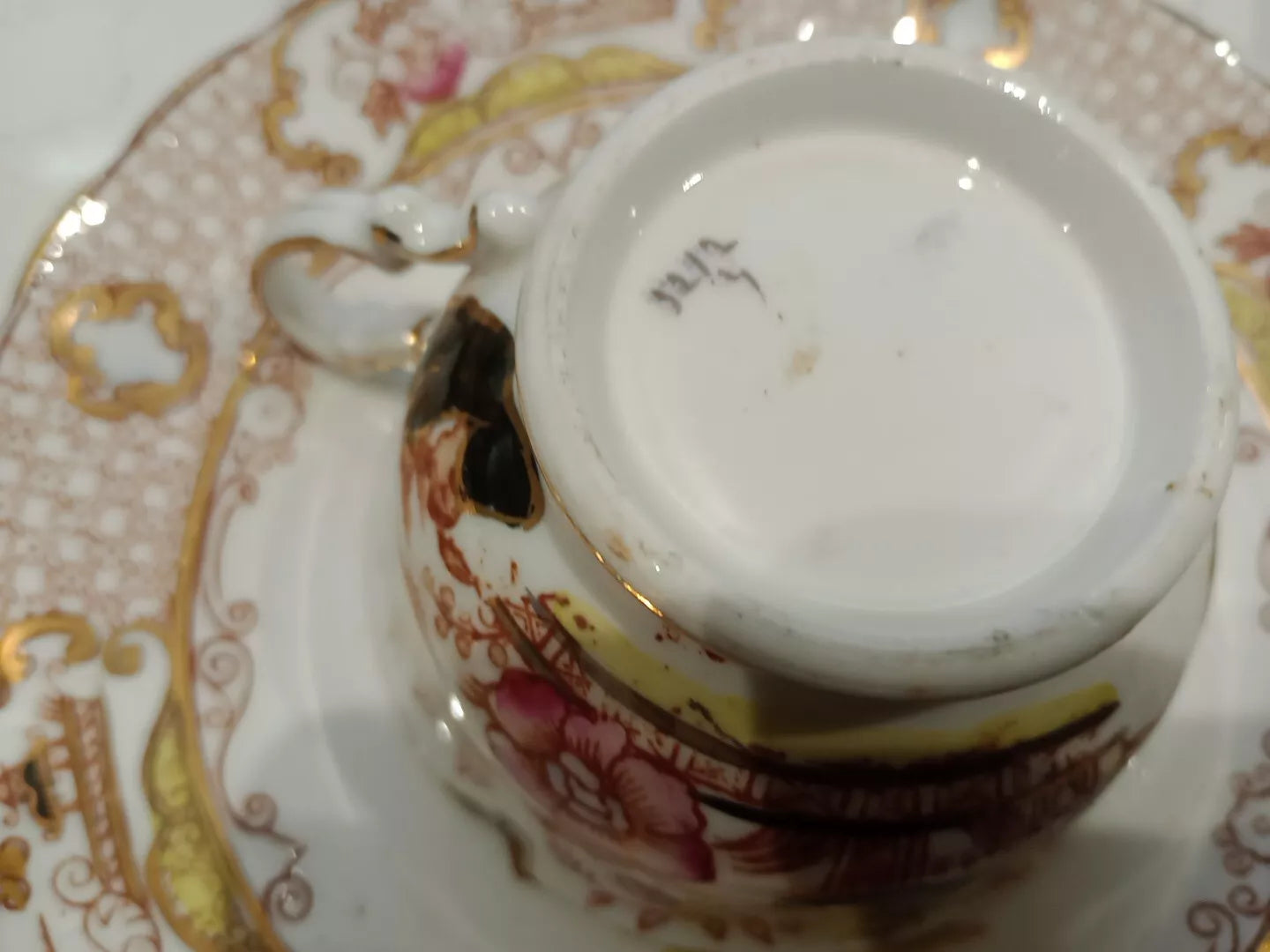 Close-up of antique Charles Amison tea trios cup and saucer with floral and gold detailing