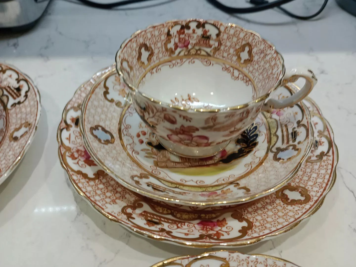 Antique Charles Amison tea trios featuring ornate gold and floral patterned cup, saucer, and plate