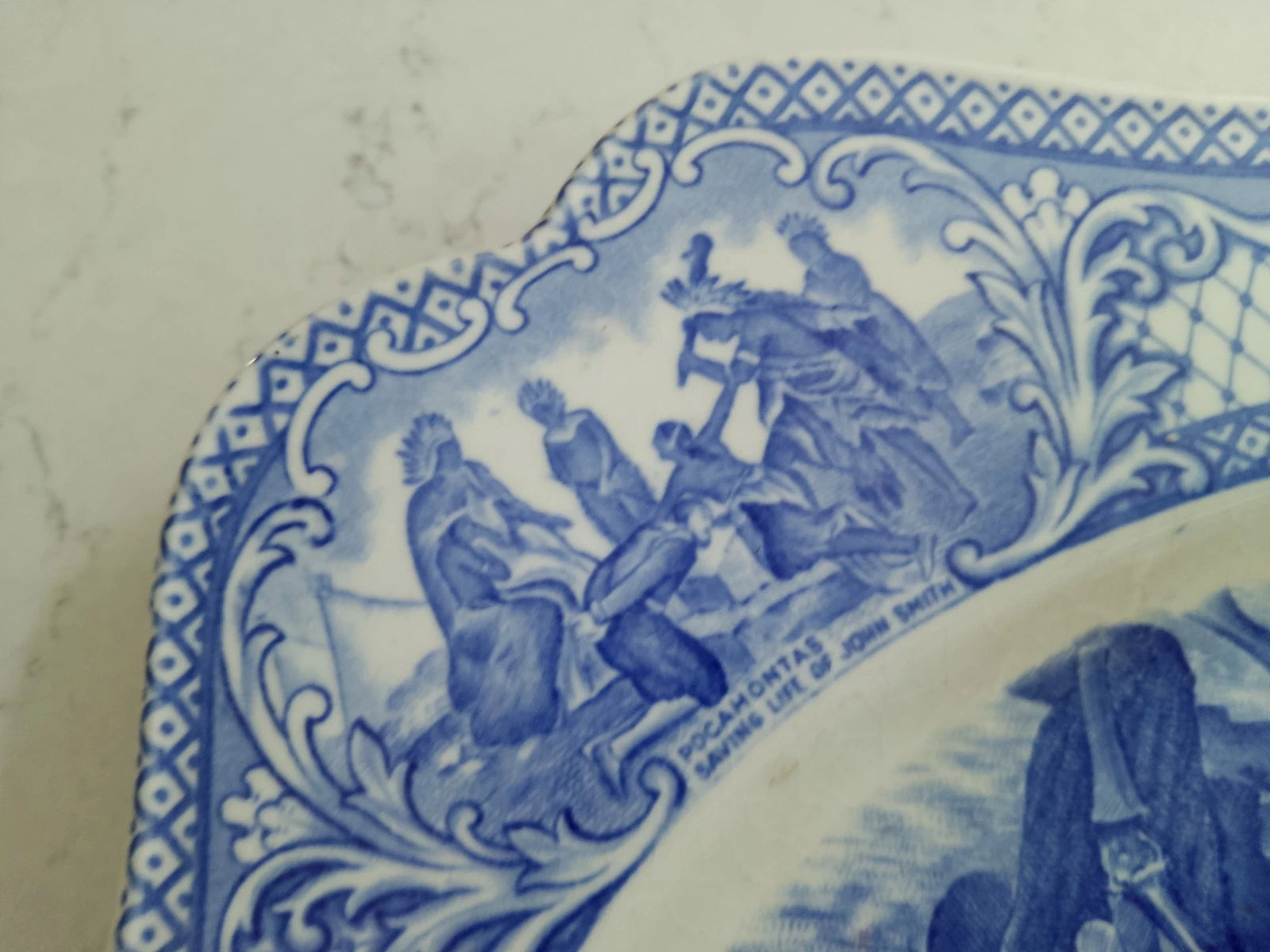 Detailed close-up of The First Sermon Ashore crown ducal plate with blue intricate design and figures
