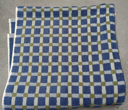 Folded DKNY bath towel with blue and olive green checkered pattern on a neutral background