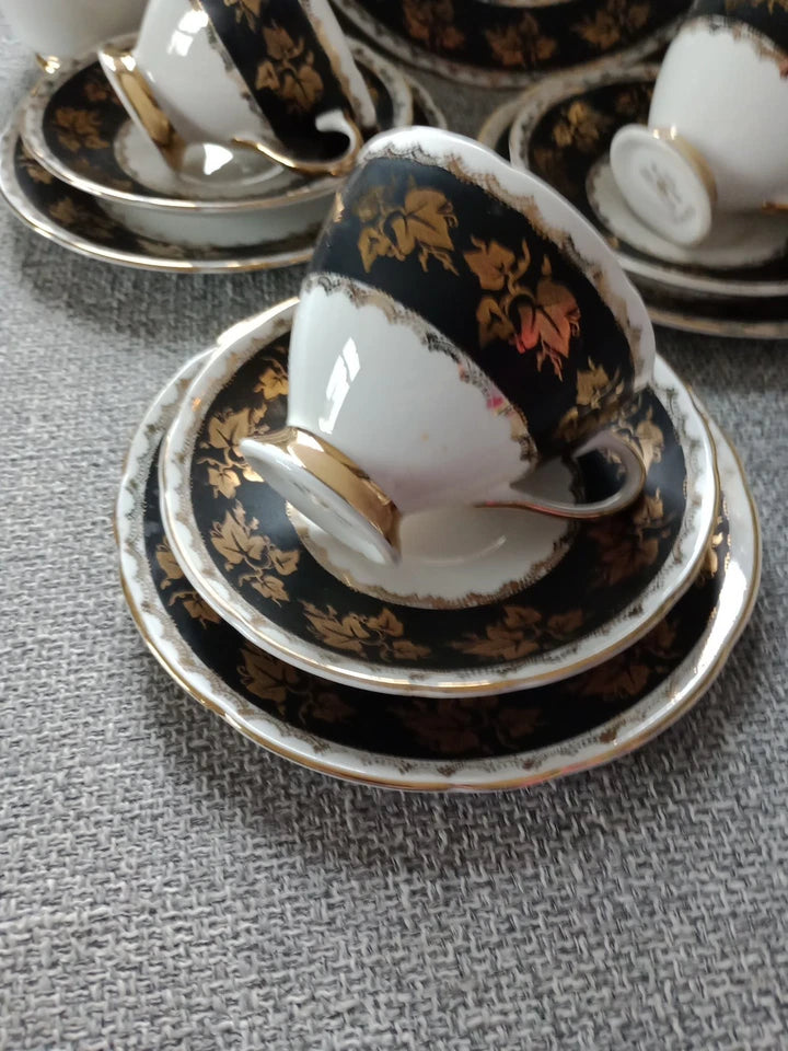 Gladstone China tea set vintage with black and gold floral design cups and saucers on grey fabric