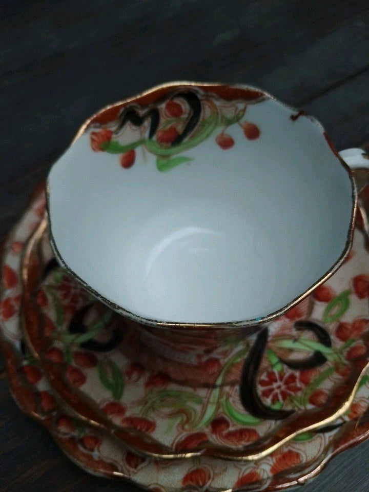 Antique Imari tea trio featuring a delicate cup and two matching saucers with floral patterns and gold trim