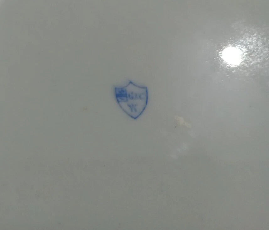 Close up of the Grainger & Co oval serving dish blue logo mark on white dinner ware