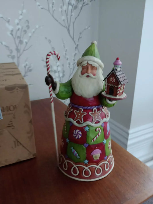 Jim Shore Santa figurine in colourful patchwork design holding a candy cane and gingerbread house