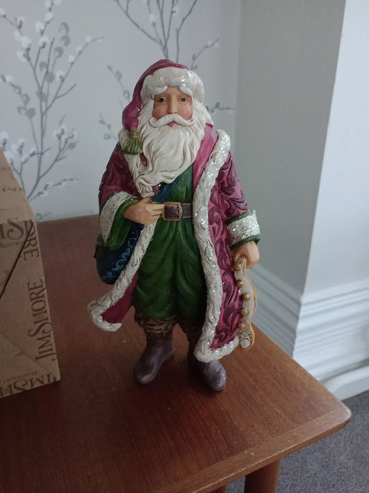 Jim Shore Victorian Santa figurine in detailed red and green robe standing on wooden table
