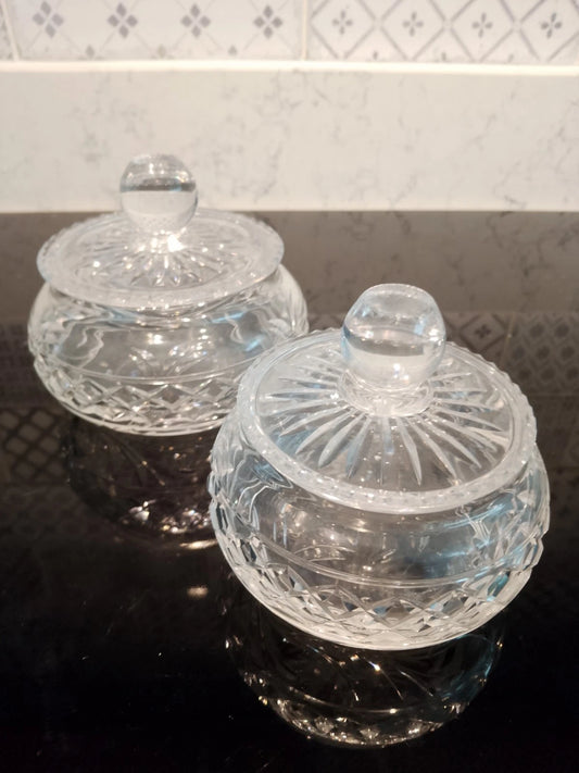 Pair of vintage Stuart crystal jars with intricate cut glass design and round lids on black surface